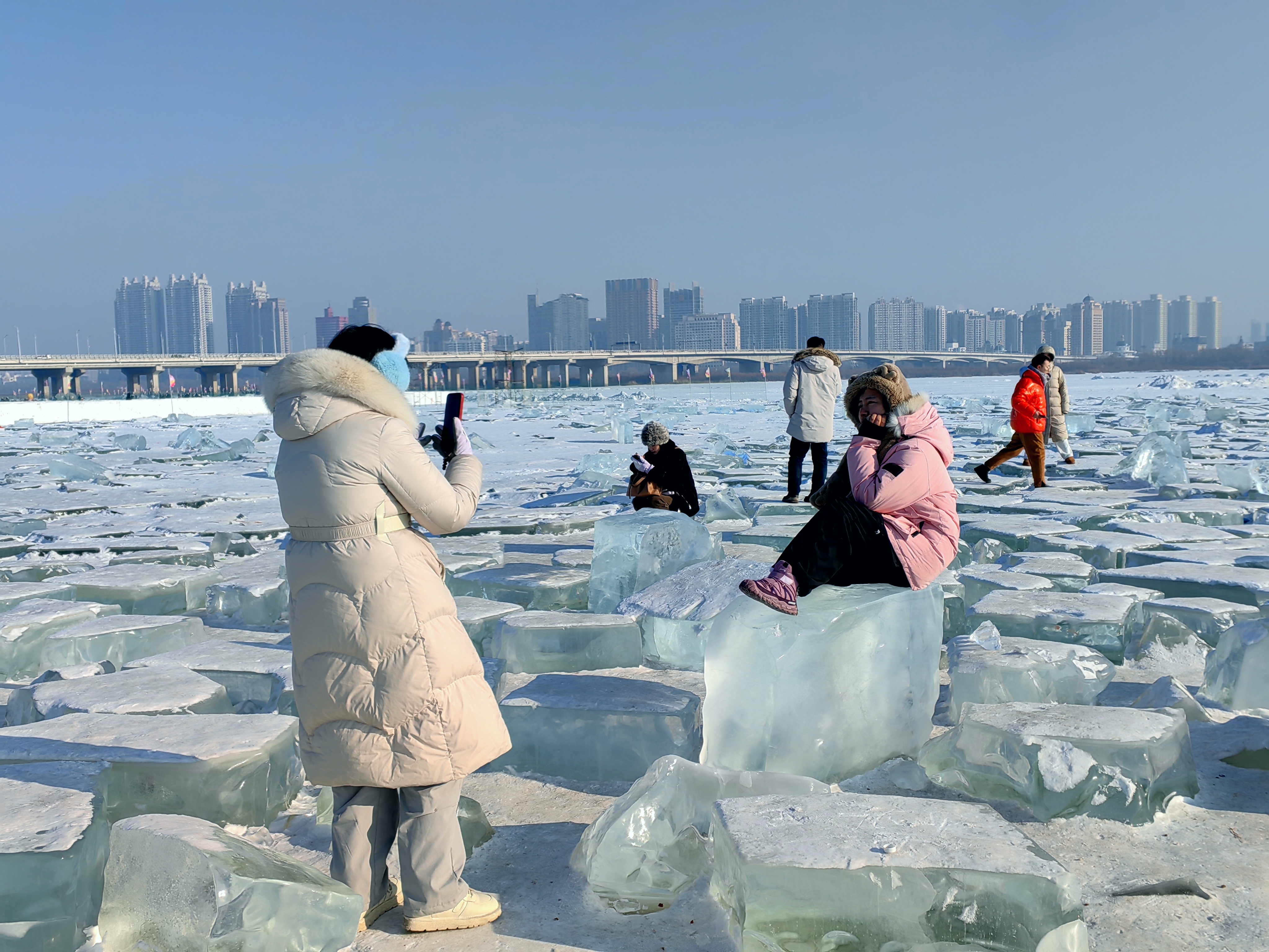 Tourists photographing ice blocks on the Songhua River in winter